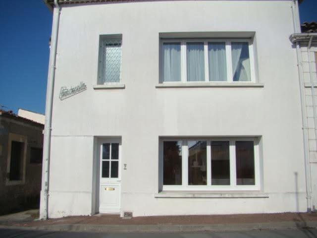 une maison blanche avec deux fenêtres et une porte dans l'établissement Villa chanterelle, à Meschers-sur-Gironde