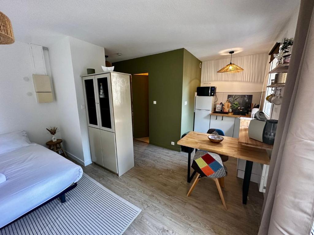 Cette petite chambre comprend un lit, une table et une cuisine. dans l'établissement Studio cosy sur cour, à Poitiers