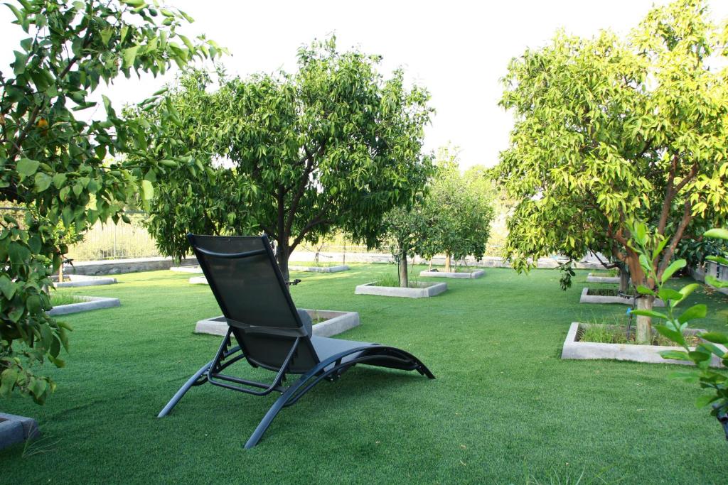 una silla sentada en el césped en un parque en DOMUS ULIVI LUXURY ROOMS Moresca, en Catania