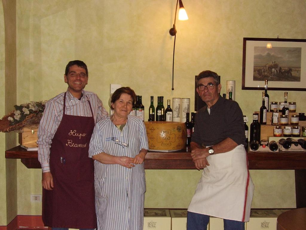 un grupo de tres personas parados frente a un bar en Agriturismo Lupo Bianco, en Monzambano