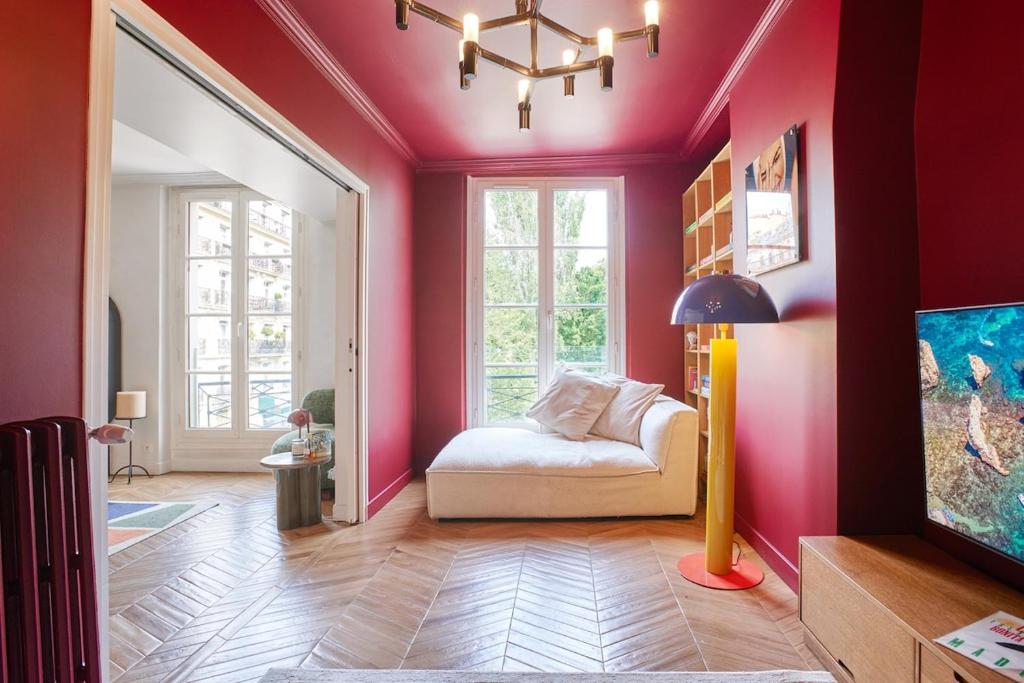 - un salon avec un canapé et un mur rose dans l'établissement Saint-Germain flat - Le Bon Marché, à Paris