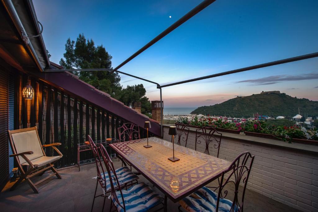 une table et des chaises sur un balcon avec vue dans l'établissement [porto ercole] comfort vista mare + parcheggio gratuito, à Cala Galera