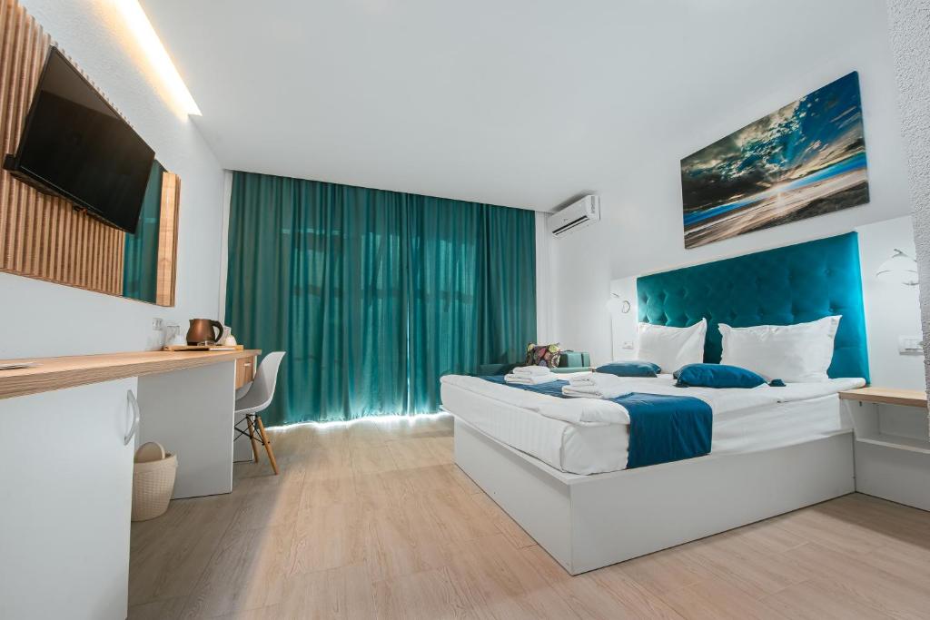 a bedroom with a large bed with a blue headboard at Complex Sea Star 2Mai in 2 Mai