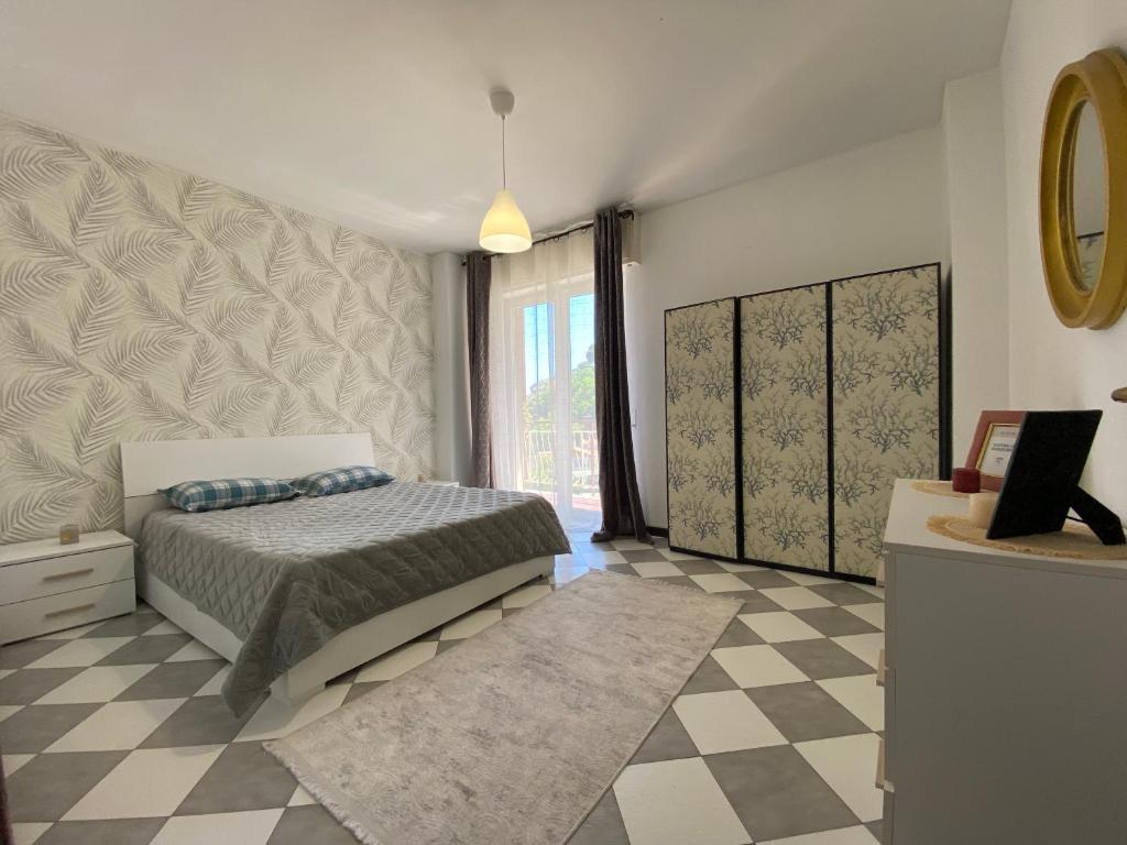 a bedroom with a bed and a checkered floor at 11 ospiti -Balcone-Parcheggio Privato, Bulai Home in Sanremo