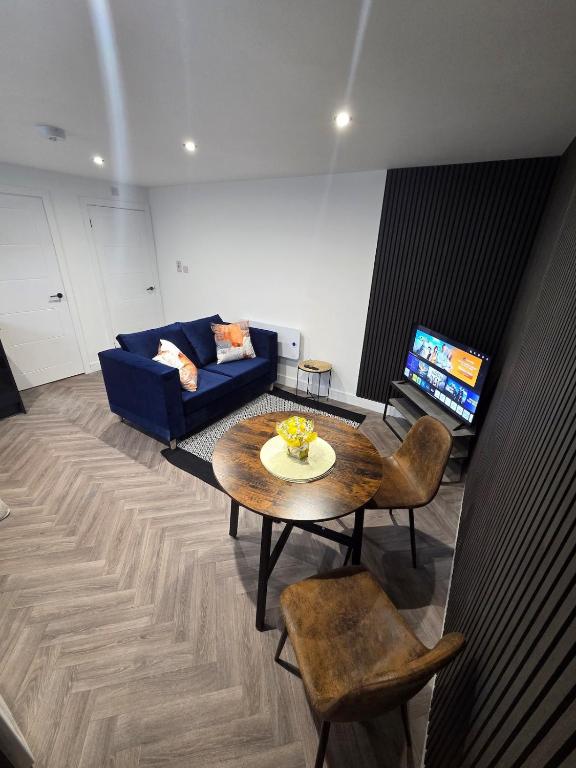 a living room with a table and a couch at Courtyard High Spec Apartment in Town Centre in Blackburn