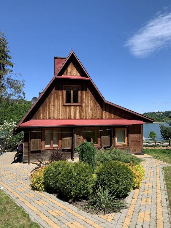 a large wooden house with a red roof at 50m od Jeziora - Dom wakacyjny in Zawóz