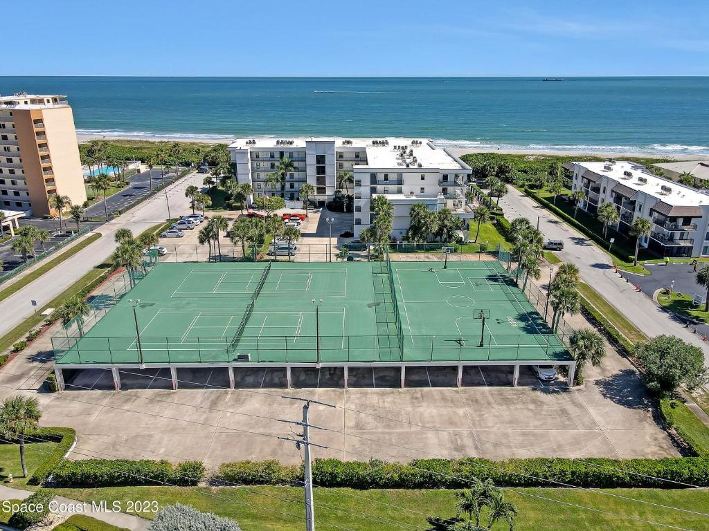 an aerial view of a tennis court in front of the ocean at Cape Winds Resort in Cape Canaveral