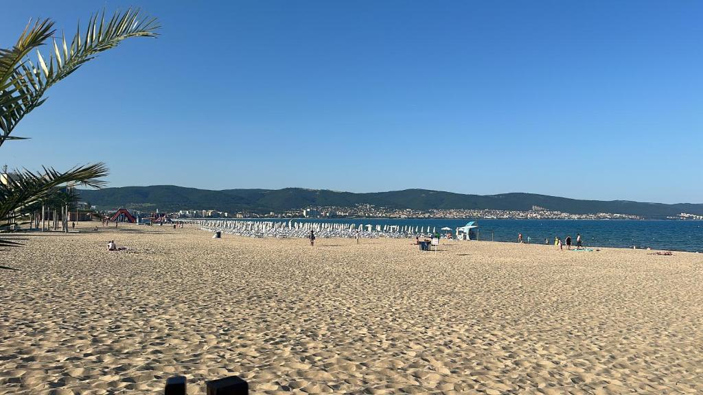 a beach with a lot of people and umbrellas at Kalia A7 Sunny Beach in Bŭnzareto