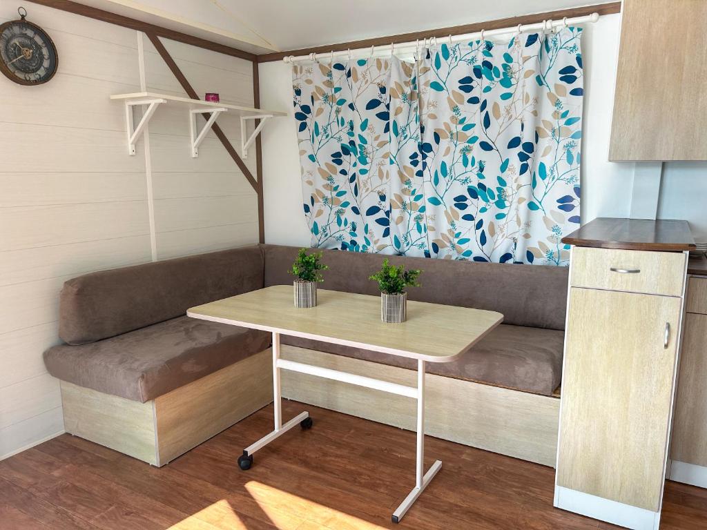 un salon avec un canapé et une table dans l'établissement Mobil-home camping 4 étoiles, à Cancale