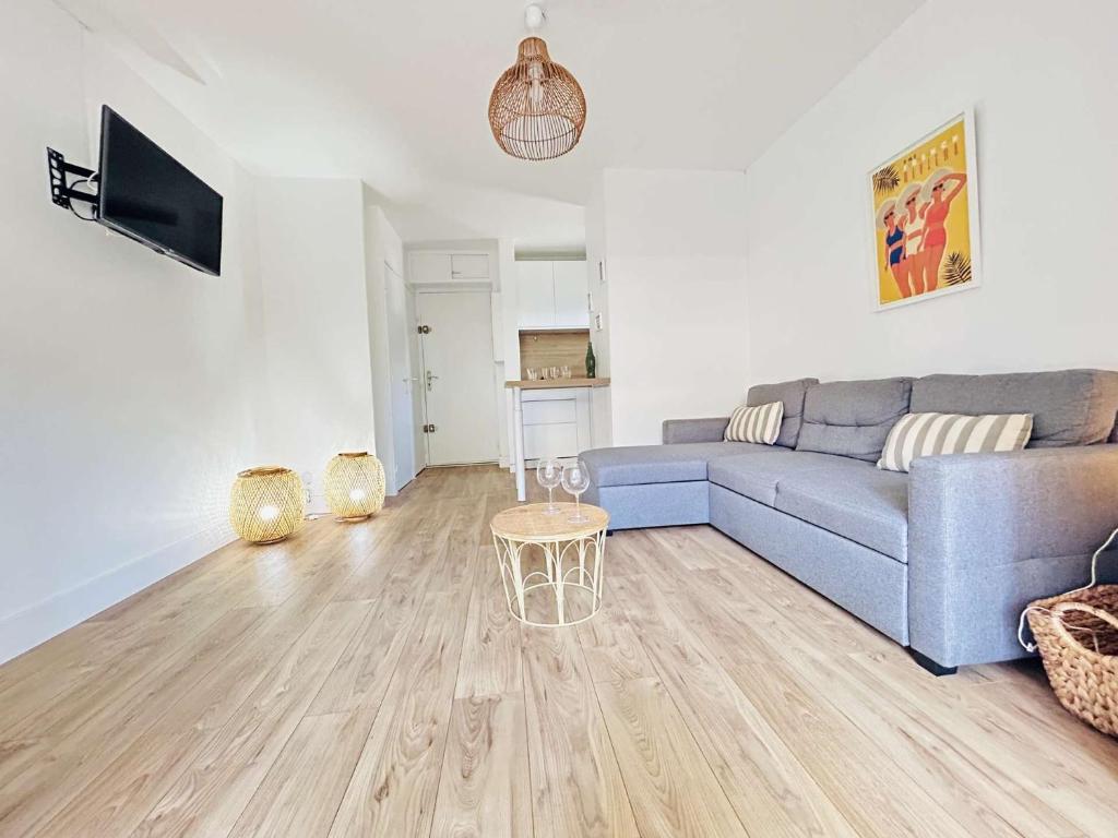 un salon avec un canapé bleu et un parquet dans l'établissement T2 Cabine Cap d'Agde CT271-027, au Cap d'Agde