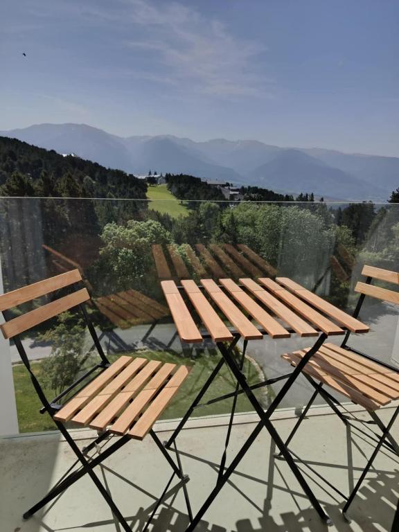 - deux chaises en bois et une table sur un balcon dans l'établissement logement avec belle vue sur montagne, à Égat