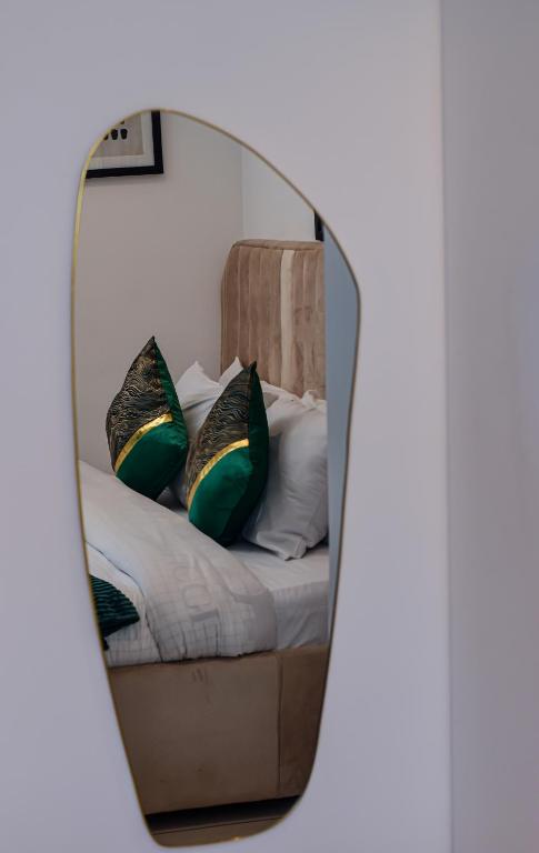a mirror reflecting a bed with pillows on it at Lovely studios at Embassy Gardens in Accra