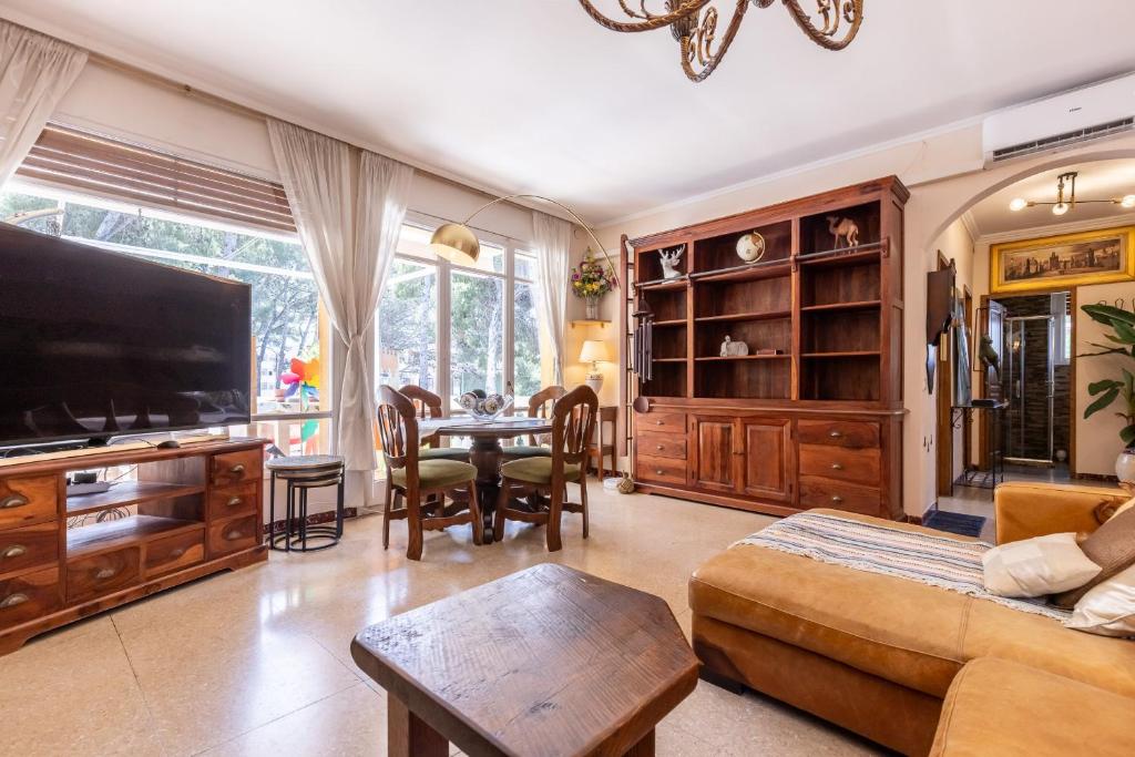 a living room with a television and a table and chairs at Villa Frades in Salou