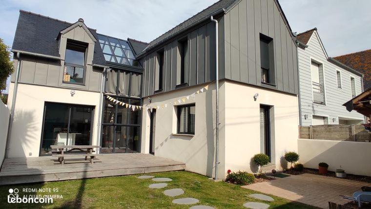 a large white house with a bench in the yard at Bon Accueil in Saint Malo