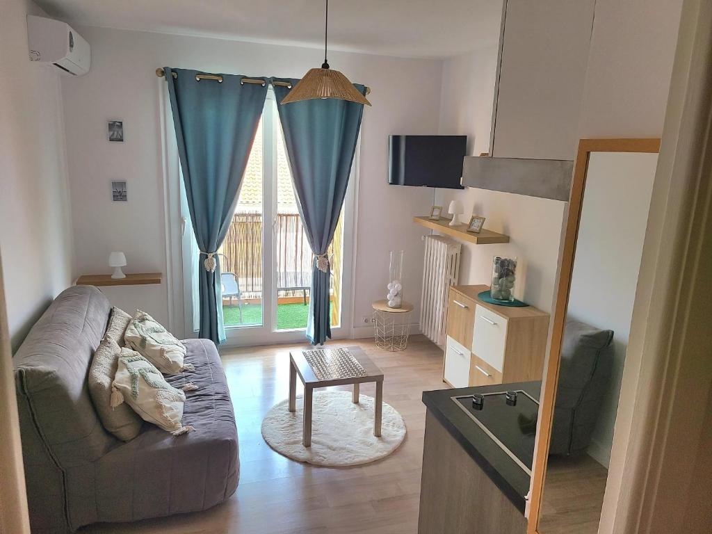 un salon avec un canapé et une table dans l'établissement Studio cosy avec terrasse à Vallauris 15 m², à Vallauris
