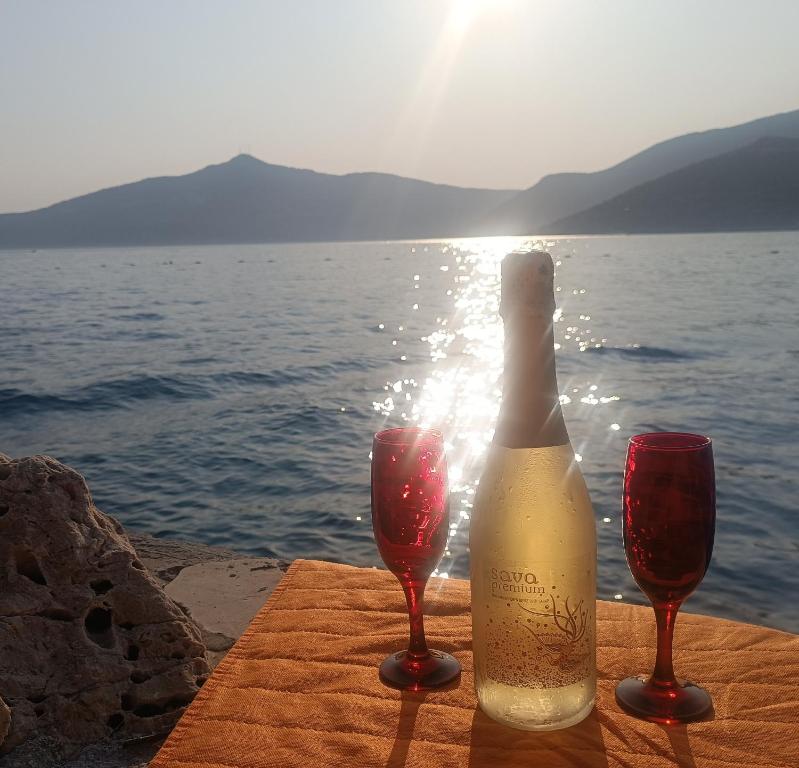 een fles wijn en twee glazen op een tafel bij het water bij Cactus Garden Kalkan - Club Patara Villas in Kalkan