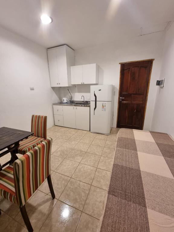 a kitchen with a table and a white refrigerator at Alojamiento Almendra in Paso de los Libres