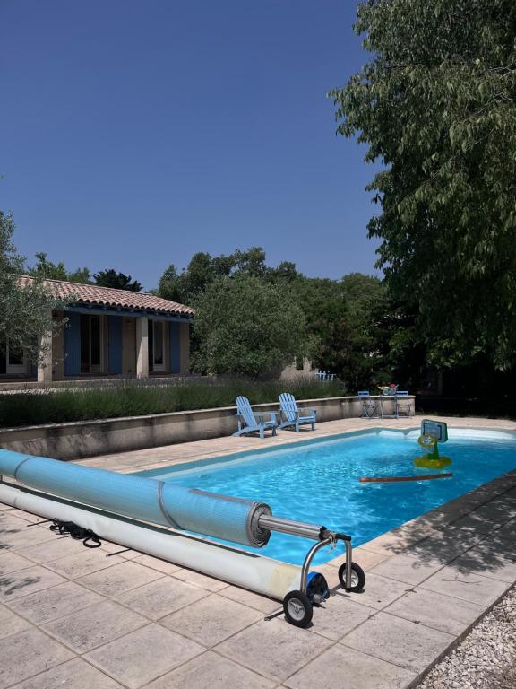 a large swimming pool with a blue pool noodle in a yard at Villa à Salazac - Piscine - Gorge de l'Ardèche in Salazac