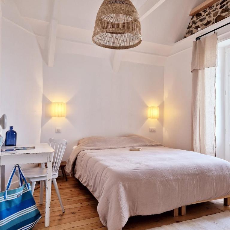 une chambre avec un lit, une table et une lampe dans l'établissement Villa Les Embruns, Villa balnéaire familiale, plages à pied, à Saint-Quay-Portrieux