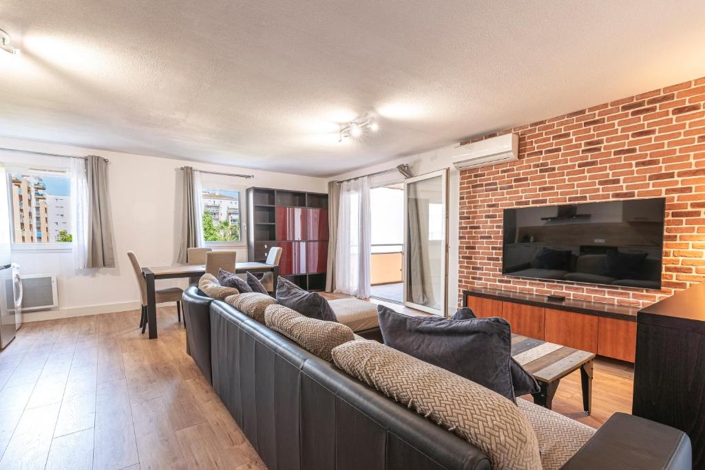 - un salon avec des canapés et un mur en briques dans l'établissement Pietra Di Mare - Au coeur d'Ajaccio, à Ajaccio