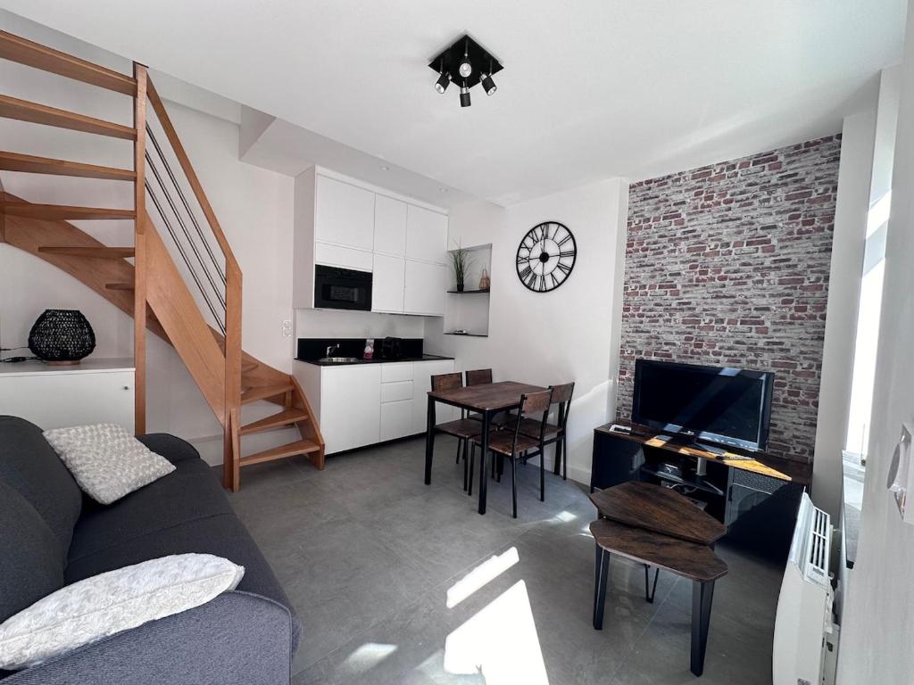 a living room with a couch and a kitchen with a table at L'épicurieux in Lille