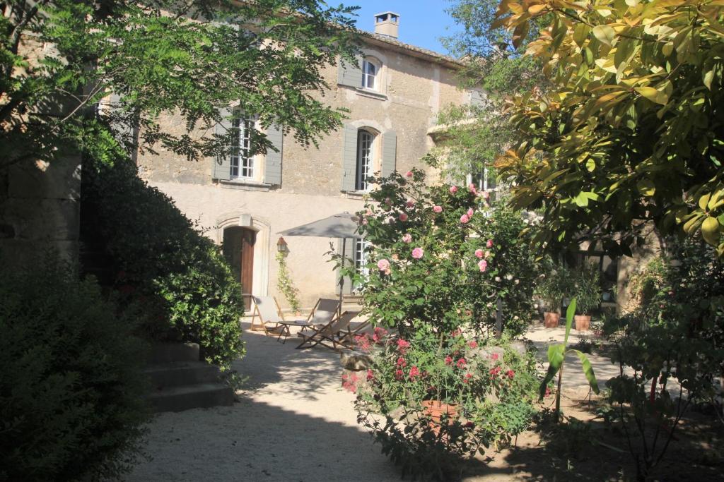 a house with a garden with flowers in front of it at Les Guillaume Rey in Oppède