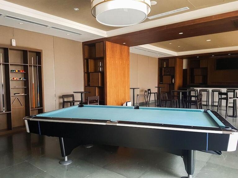 a pool table in a room with a bar at Minimalist Designer Style Apartement Branz BSD 1BR in Samporo
