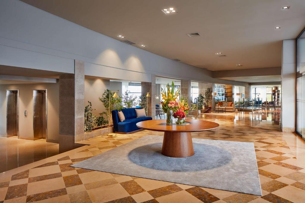 a lobby with a table with flowers on it at NH Sintra Centro in Sintra