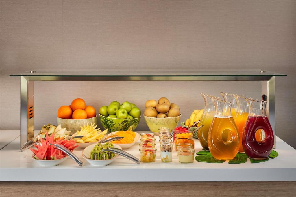 a display of fruits and vegetables and drinks on a table at NH Sintra Centro in Sintra