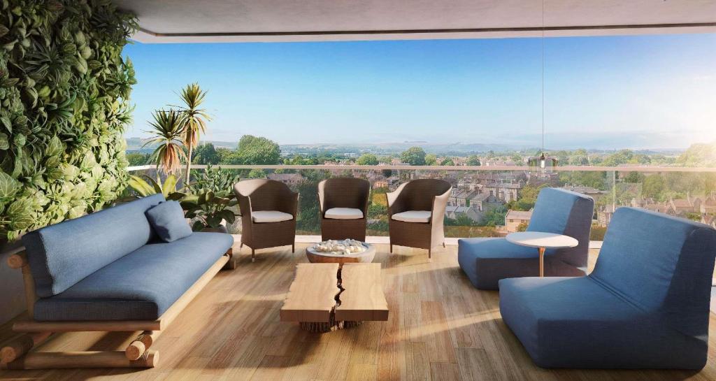 a living room with blue furniture and a large window at NH Sintra Centro in Sintra