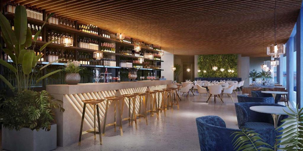 a restaurant with a bar with tables and chairs at NH Sintra Centro in Sintra