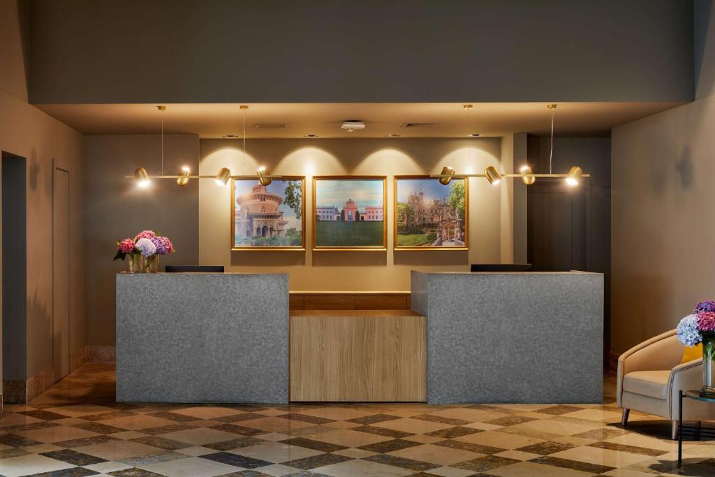 a lobby with a waiting area with flowers on display at NH Sintra Centro in Sintra