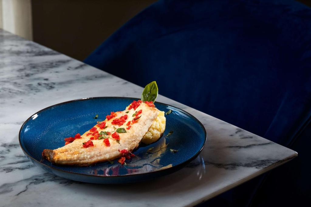 a piece of food on a blue plate on a table at NH Sintra Centro in Sintra