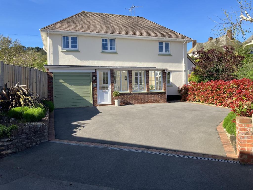 a house with a driveway with a garage at Barn Cottage, Minehead in Minehead