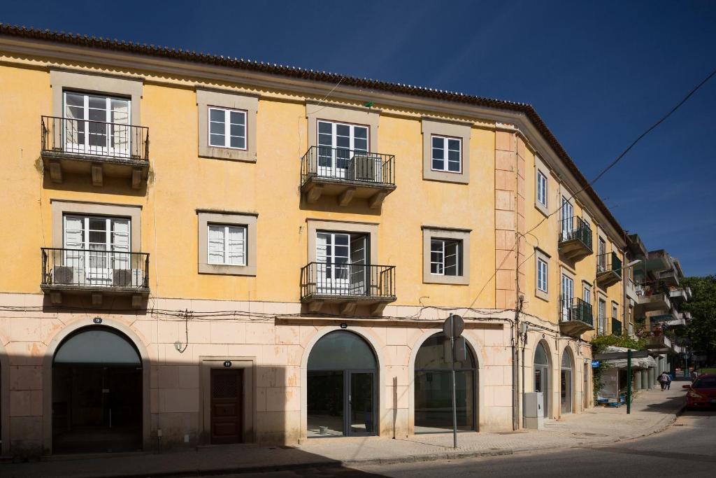 a large yellow building with balconies on a street at Flattered to be in Tomar in Tomar