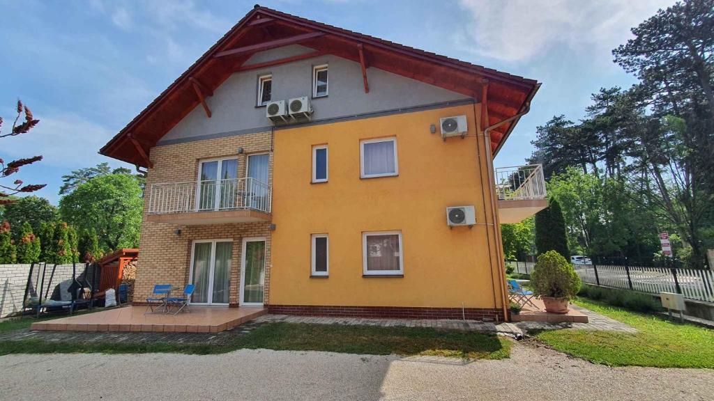mały żółty dom z czerwonym dachem w obiekcie Apartments in Siofok/Balaton 35466 w Siófoku