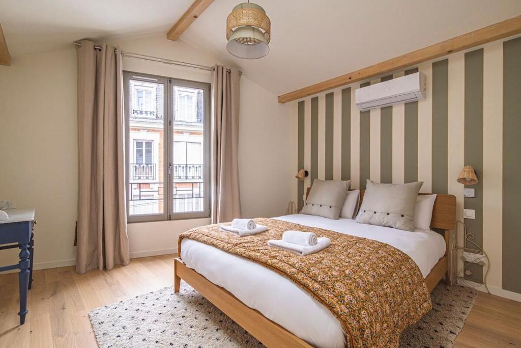 une chambre avec un grand lit et une fenêtre dans l'établissement Millésime Duplex, Centre de Reims, à Reims