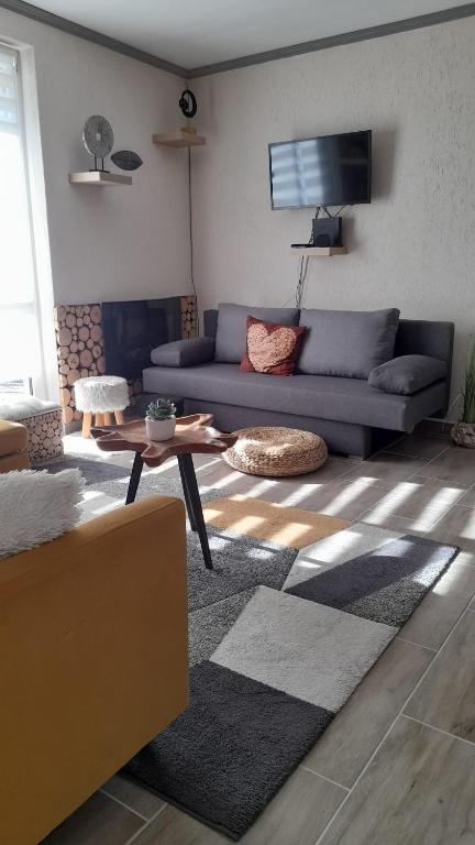 a living room with a couch and a table at Chill and Relax Apartman Kehidakustány in Kehidakustány