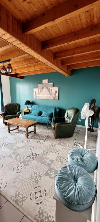 a living room with a blue couch and chairs at Le Duplex Charentais in Saint-Jean-dʼAngély