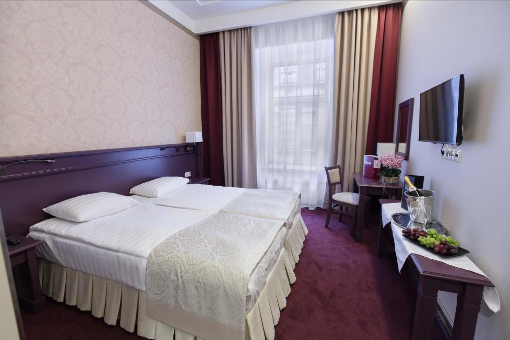 a hotel room with a bed and a desk and a window at The Bridge Hotel in Saint Petersburg