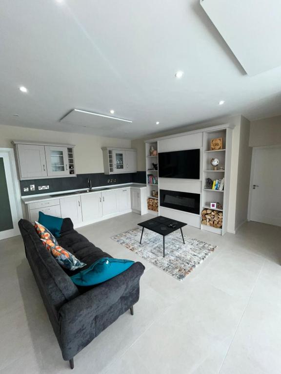 a living room with a couch and a table at Oakdale Lodge in Derrymore Bridge
