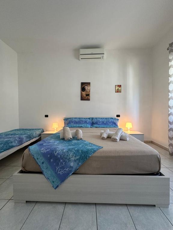 a bedroom with a large bed with blue sheets at Soulmondo Mare Apartment in Campomarino