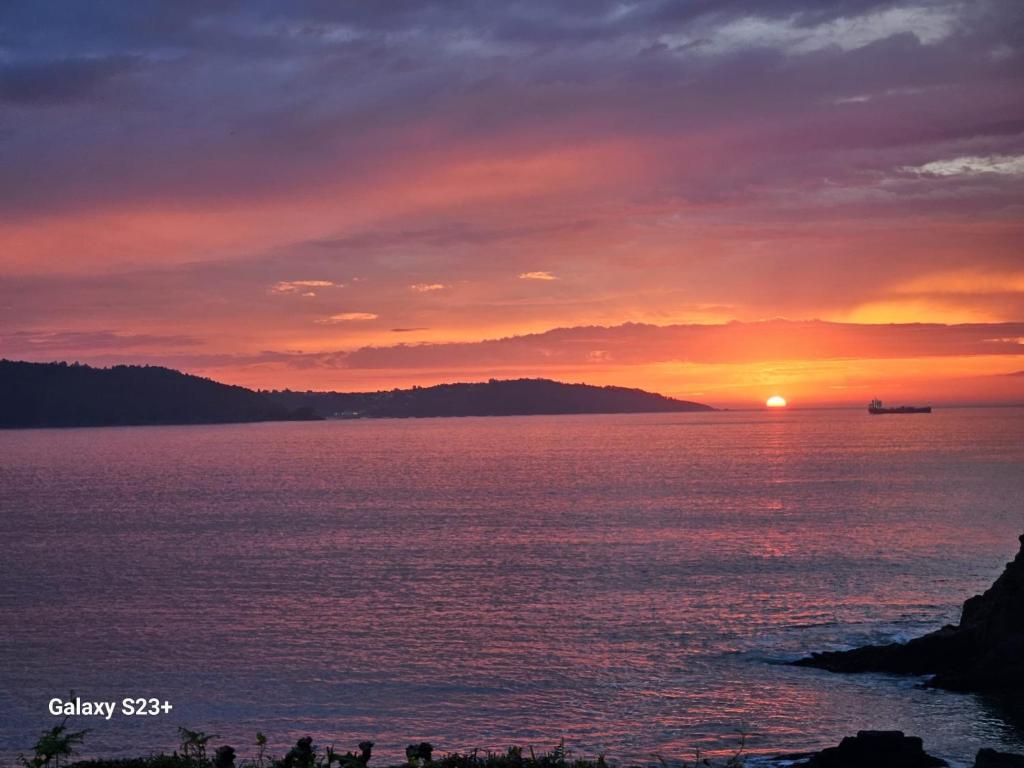 a sunset over the ocean with a boat in the distance at Perbes Dreams in Perbes