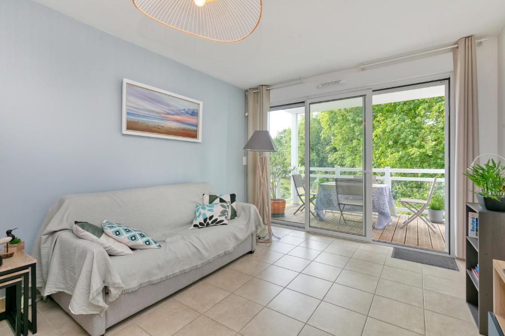 d'un salon avec un canapé et un balcon. dans l'établissement 01 Appartement La Ria, à Pornic
