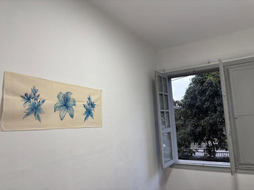 a painting of flowers on a wall next to a window at Encanto Imperial in Petrópolis