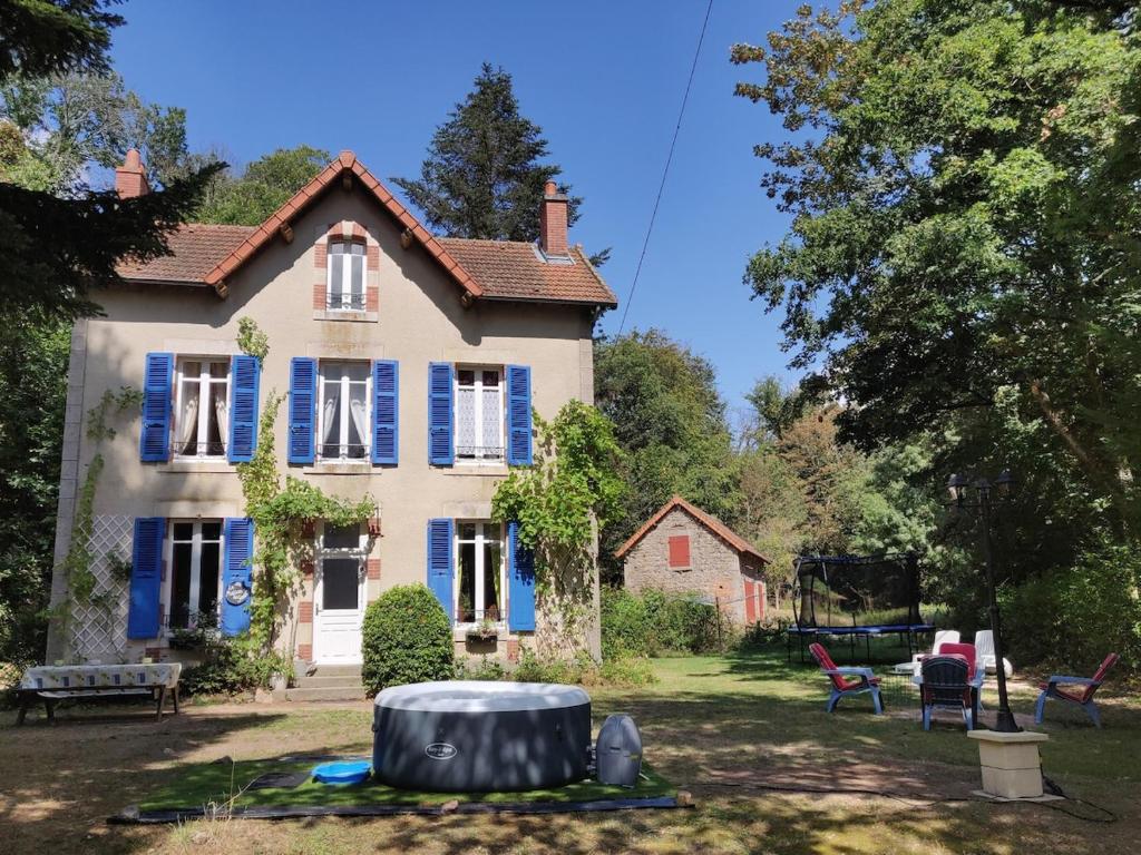 une vieille maison avec des volets bleus sur une cour dans l'établissement Romantic 19th century house with large garden and BBQ, à La Celle-sous-Gouzon