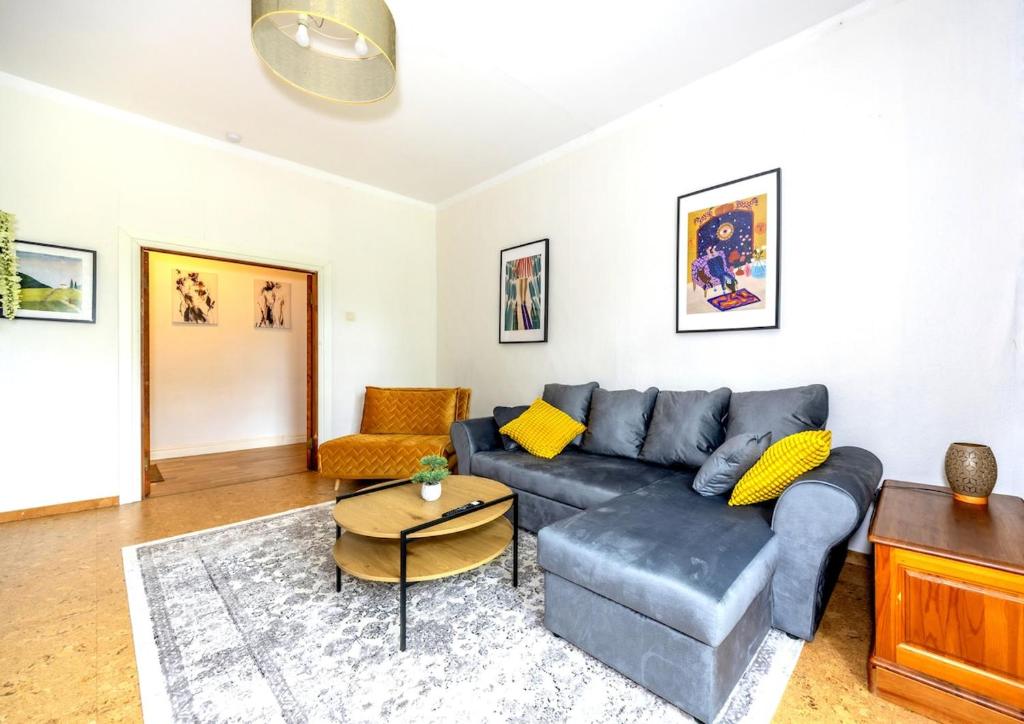 a living room with a blue couch and a table at City center, High ceilings, 75m2 2BR Free parking in Tallinn