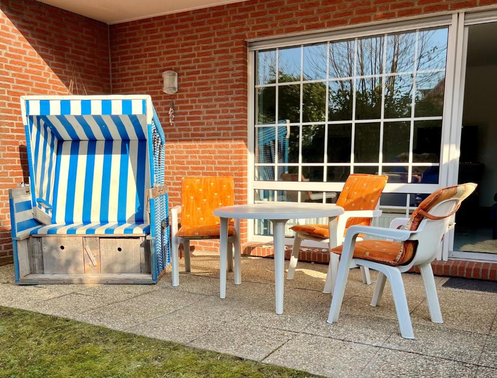two chairs and a table and chairs on a patio at MeeresZeit in Langeoog