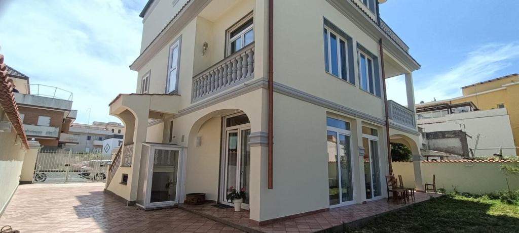una grande casa bianca con un patio di fronte di Villa Ginevra ad Anzio