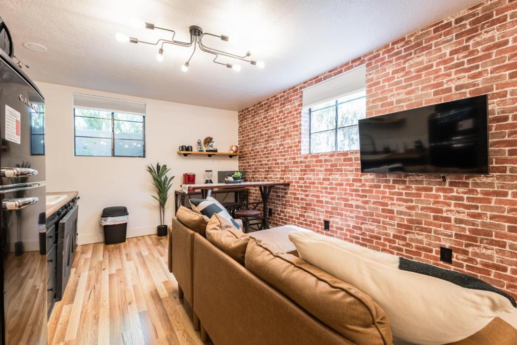a living room with a couch and a brick wall at Awaken Your Senses King Bed Bsu Parking in Boise